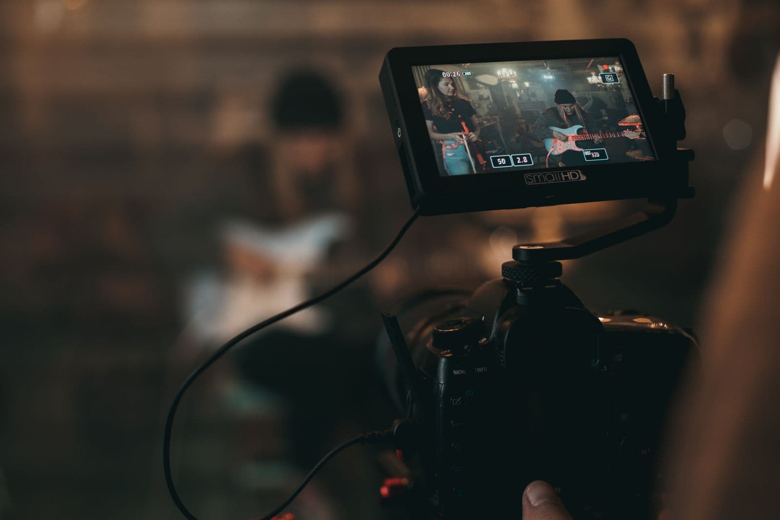 A filmmaker checking a shot on a camera monitor in a dark studio