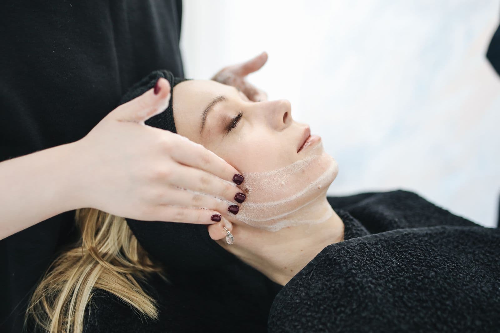 A practitioner performing a facial treatment in a calm clinic setting