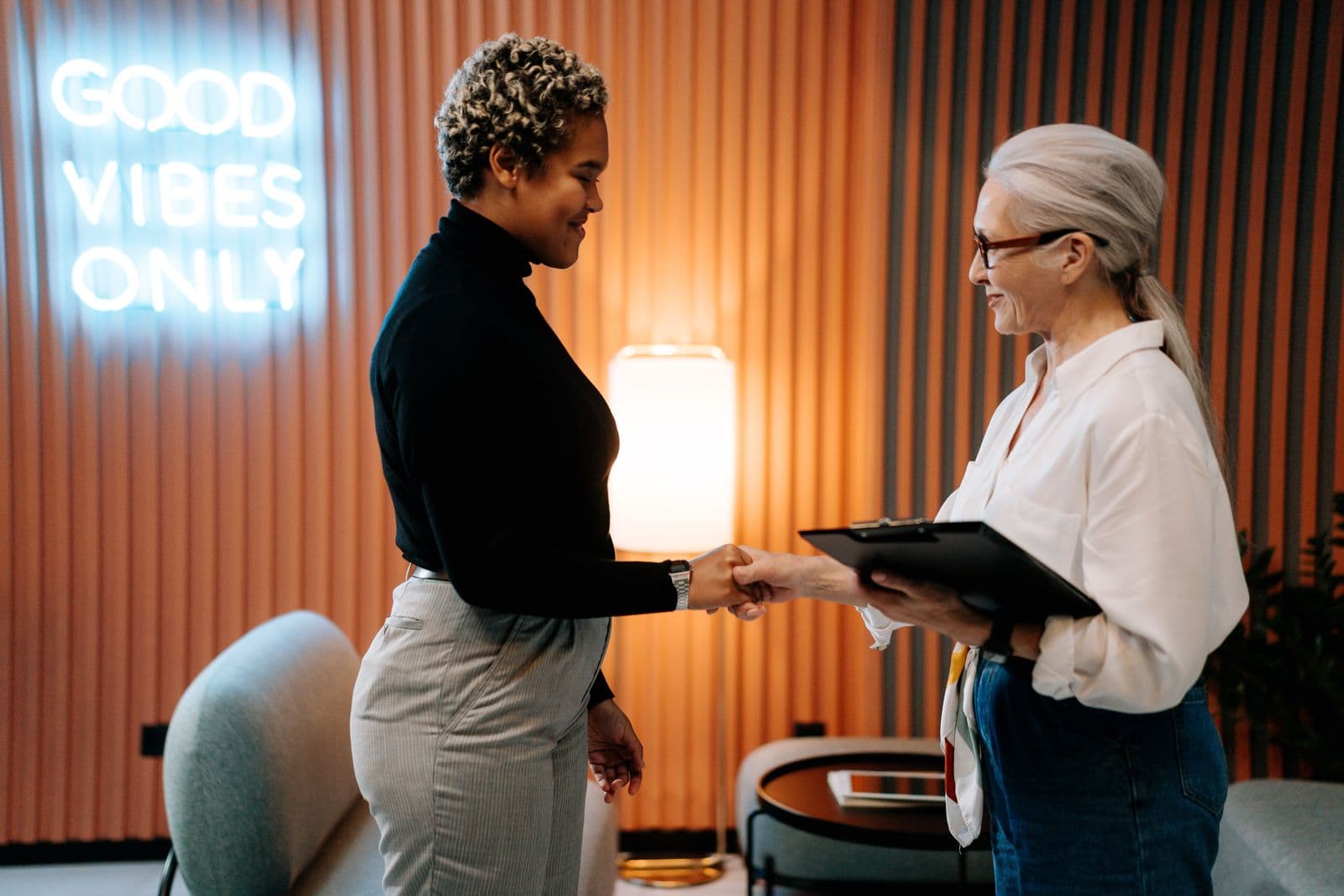 Two professionals greeting each other in a warm, modern office